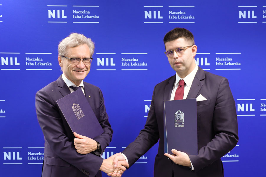 Two men dressed in suits shake hands, holding briefcases in their other hands