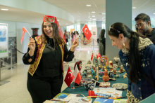 A laughing girl at the Turkish stand. She holds flags of Turkey in her hands.