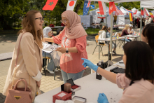 Two laughing girls. One dressed in European style, the other in hijab.