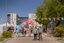 A street where a colorful "gate" of balloons was laid out. People are walking along the street.