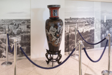 Tall black vase with dragon motifs.