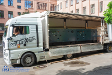 A truck with an open trailer containing a power generator.