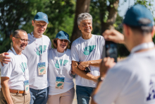 Na pierwszym planie od tyłu widoczny fotograf, który robi zdjęcie czterem osobom.