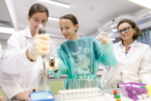 Young people in medical aprons conduct tests in the lab.