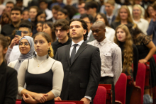 Young people dressed elegantly stand at attention.