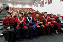 A collection of people of different ages dressed in academic clothing of different colours