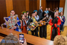 Grupa osób ubranych w stroje ludowe. Dwoje z nich gra na gitarach