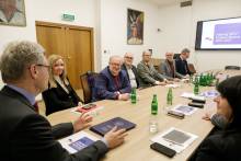 A group of people sit around a conference table and discuss