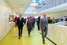 A group of people walk down a hospital corridor